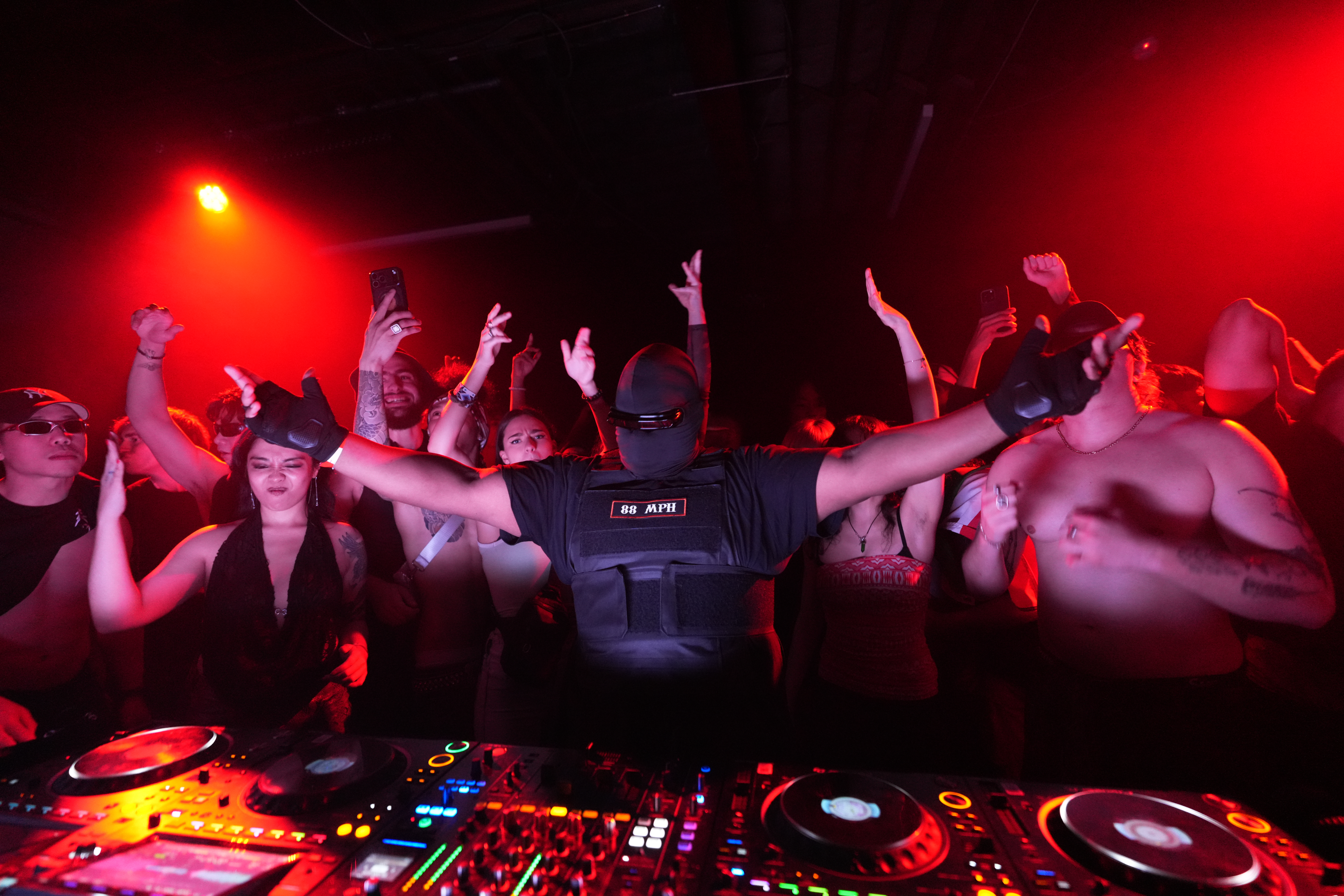88 MPH live — crowd with hands raised under red lights